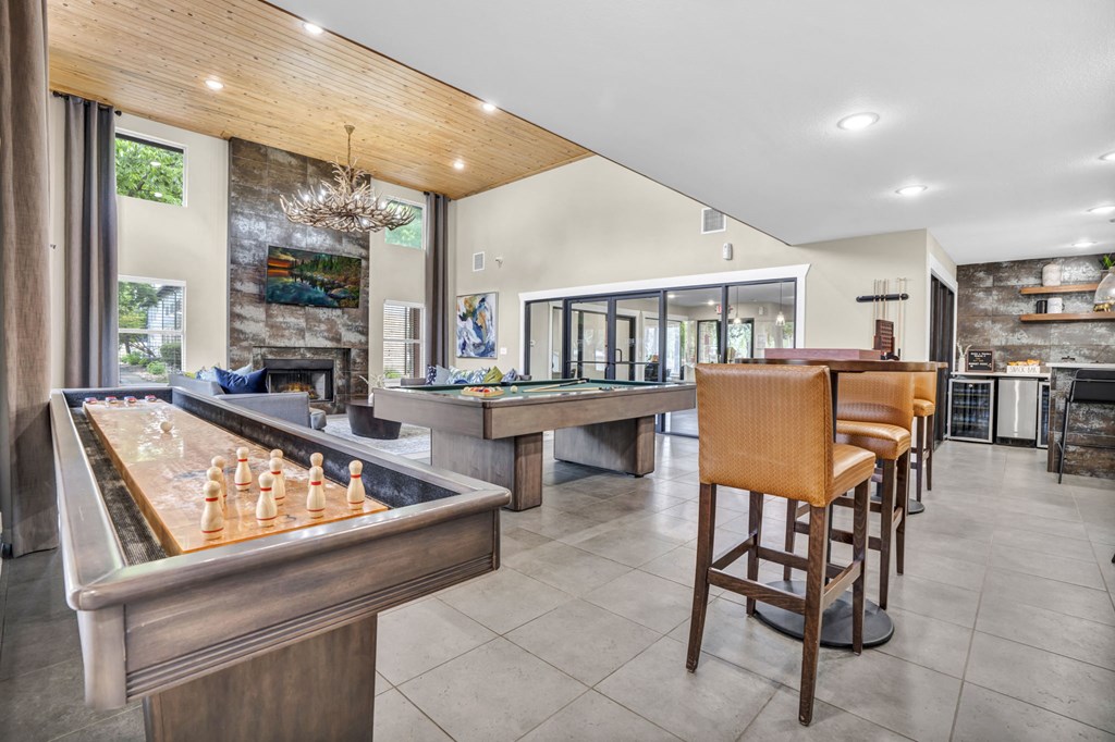 a game room with a bar and a pool table