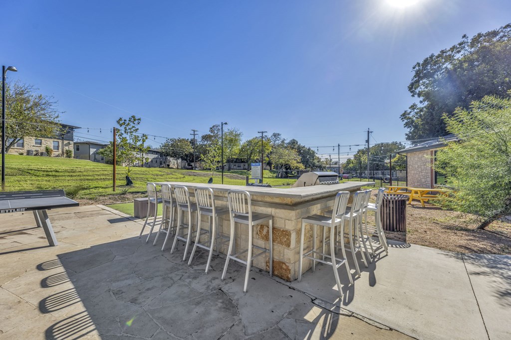 a patio with a table and chairs in a park  at Sunset Ridge, Texas, 78209
