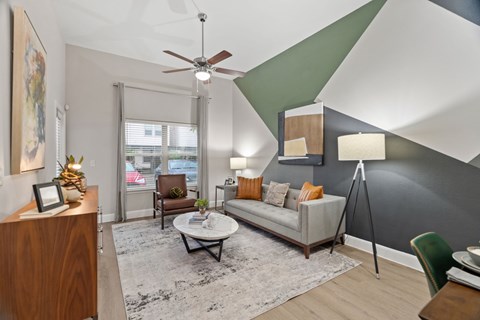 A living room with a white couch and a ceiling fan.