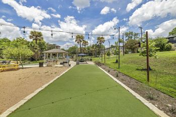 a green pathway leads to a gazebo in a park with palm trees  at Sunset Ridge, Texas, 78209