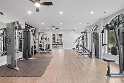 Spacious fitness center with professional workout equipment at Nalle Woods of Westlake Apartments, Austin