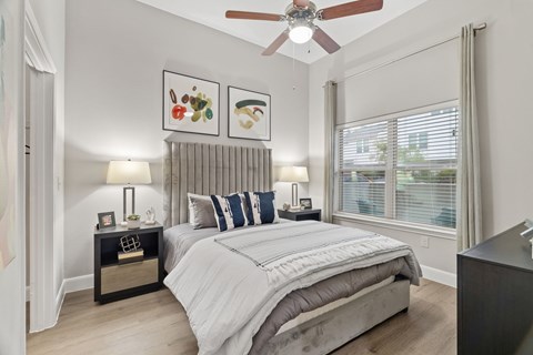 A bedroom with a large bed and a ceiling fan.