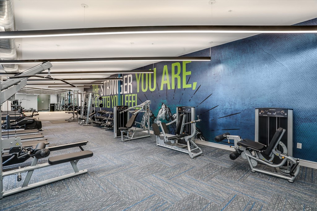 a gym with cardio machines and a wall with you are what you are at Beekman on Broadway, Michigan, 48105