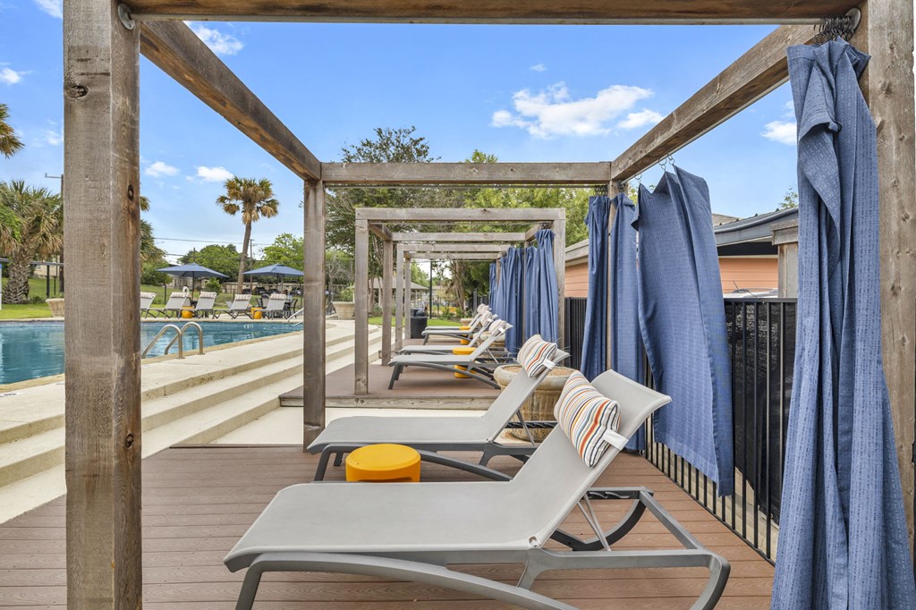 a poolside deck with lounge chairs and umbrellas  at Sunset Ridge, San Antonio, 78209