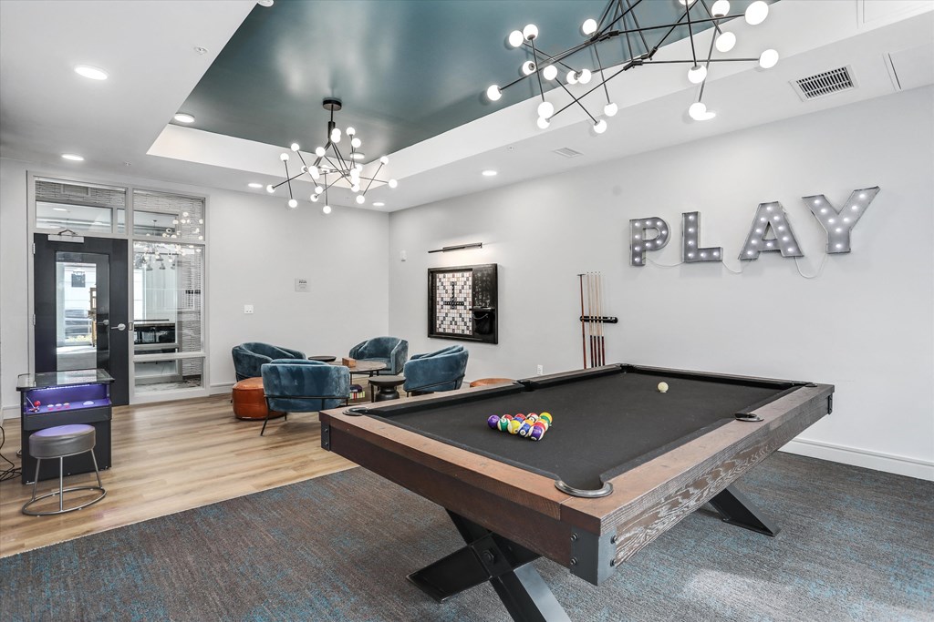 a game room with a pool table and a play area with chairs at Beekman on Broadway, Ann Arbor, MI, 48105