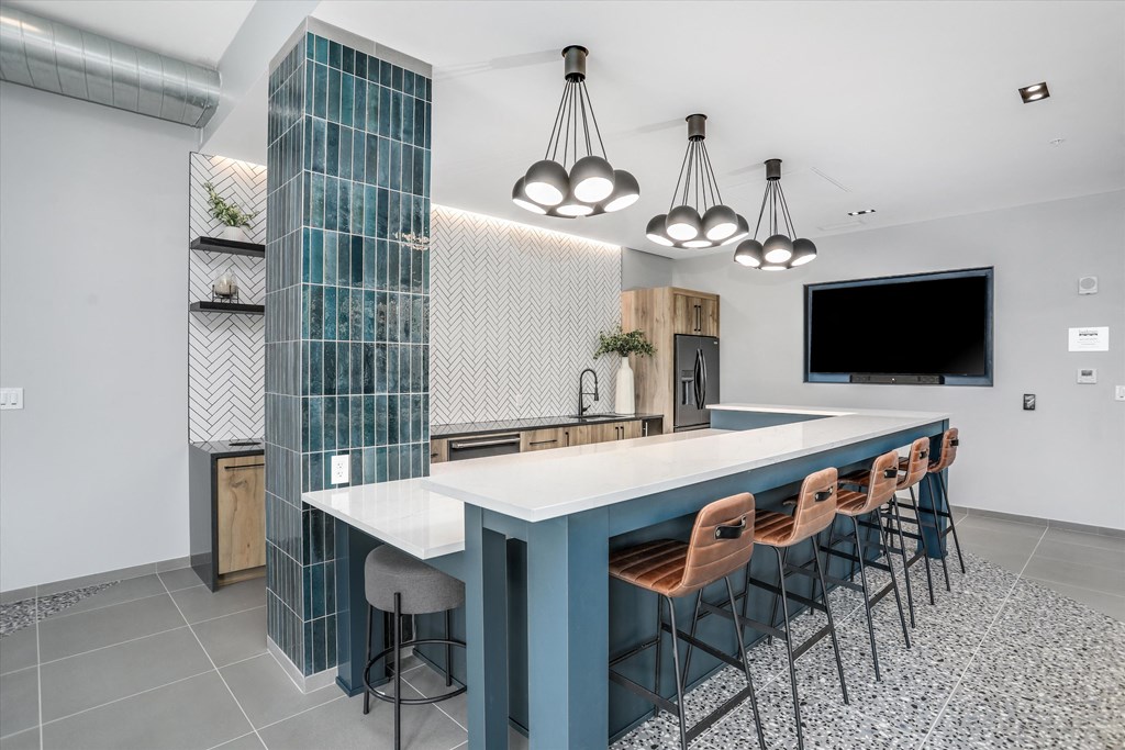 a large kitchen with a blue counter top and chairs at Beekman on Broadway, Michigan, 48105