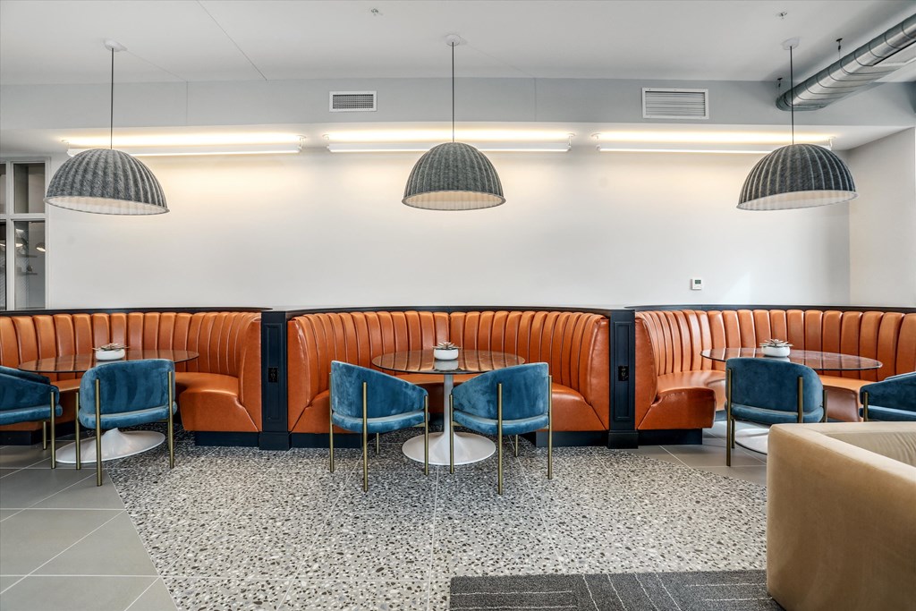 a restaurant with orange booths and blue chairs and tables at Beekman on Broadway, Ann Arbor, MI, 48105