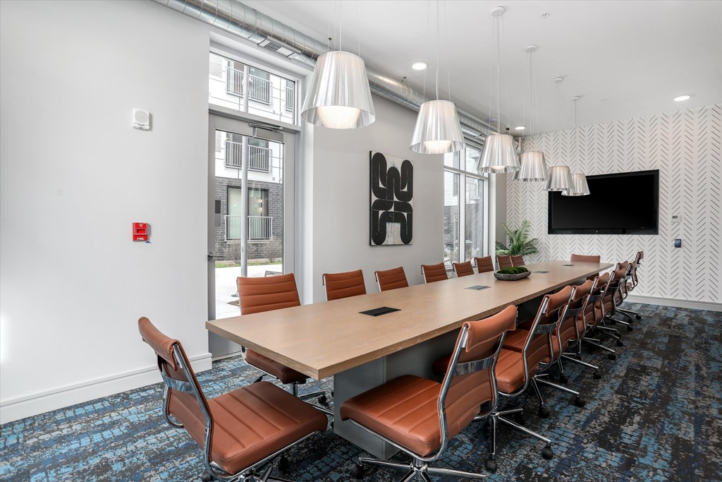 a conference room with a long table and chairs and a tv at Beekman on Broadway, Ann Arbor, MI