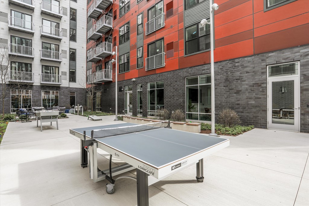 a ping pong table in the lobby of a building with pipes on the wall at Beekman on Broadway, Ann Arbor, Michigan
