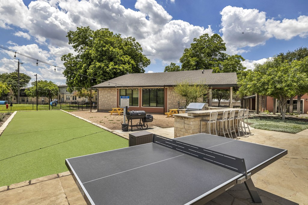 a tennis court and ping pong table in the backyard of a home  at Sunset Ridge, San Antonio