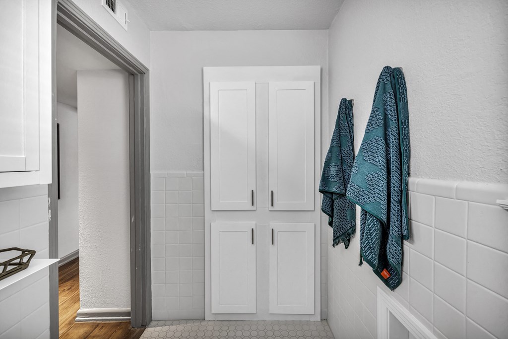 a bathroom with a white door and a blue towel hanging on the wall  at Sunset Ridge, San Antonio, TX