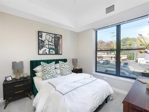 A bedroom with a large bed and a painting on the wall.