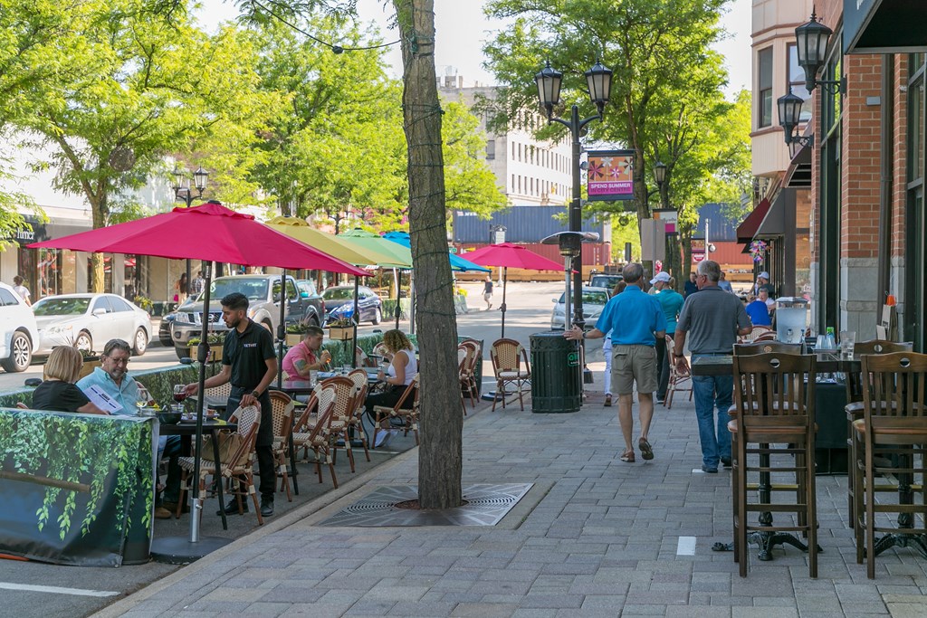 people sitting at tables on a sidewalk in front of a restaurant  at Elmhurst 255, Elmhurst