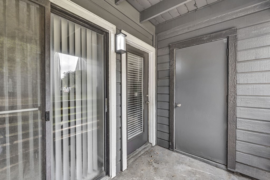 the front door of a home with a glass door and a glass screen door to
