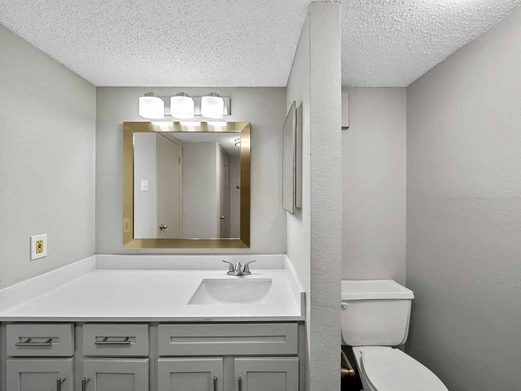 Bathroom with a sink and toilet at Trinity Apartments, Irving, Texas