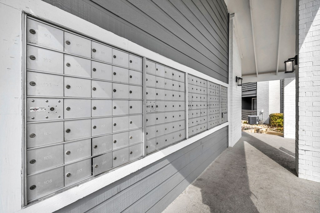 the lockers in the hallway of the building are white and stainless steel