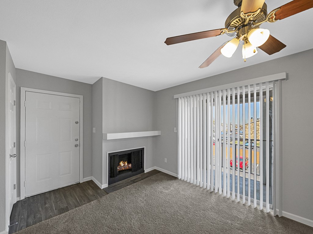 a living room with a fireplace and a ceiling fan