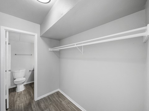 an empty bathroom with a white toilet and a white closet