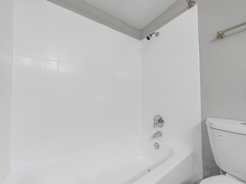 a white bathroom with a tub and a toilet