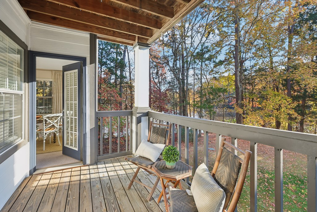 A wooden deck with a chair and a table.