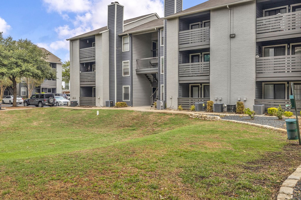 an apartment building with a green lawn in front of it