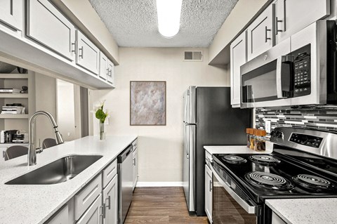 a kitchen with stainless steel appliances and white cabinets
