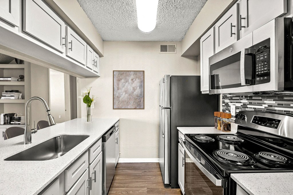 a kitchen with stainless steel appliances and white cabinets