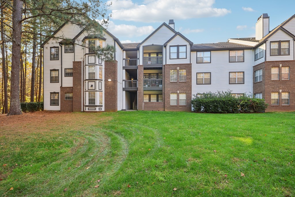 Apartment complex with a green lawn in front.