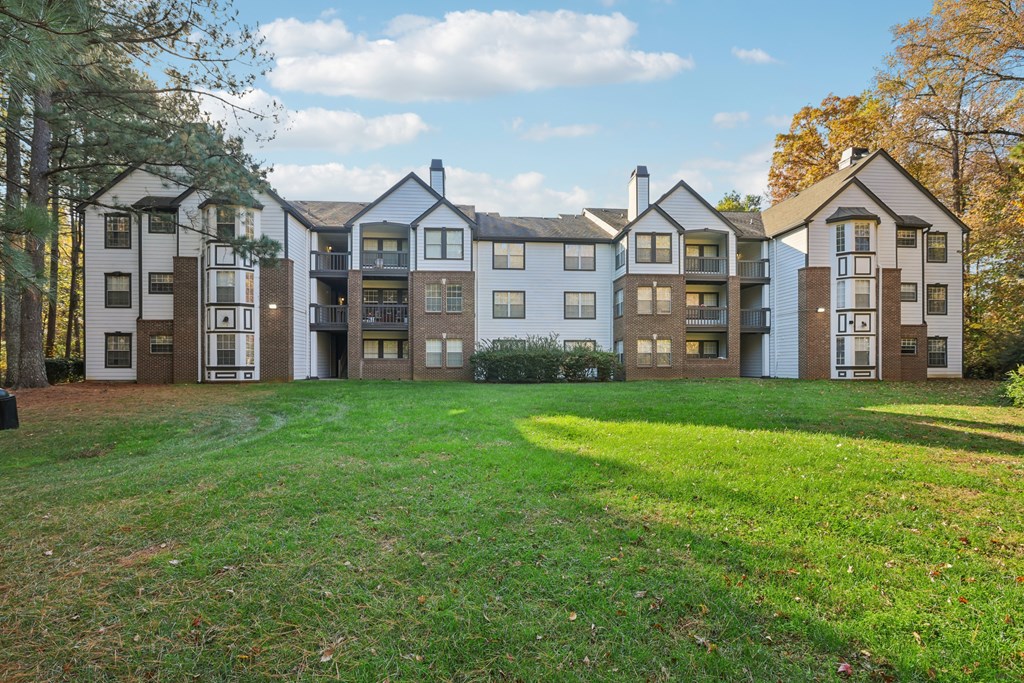 A large grassy area in front of apartment buildings.