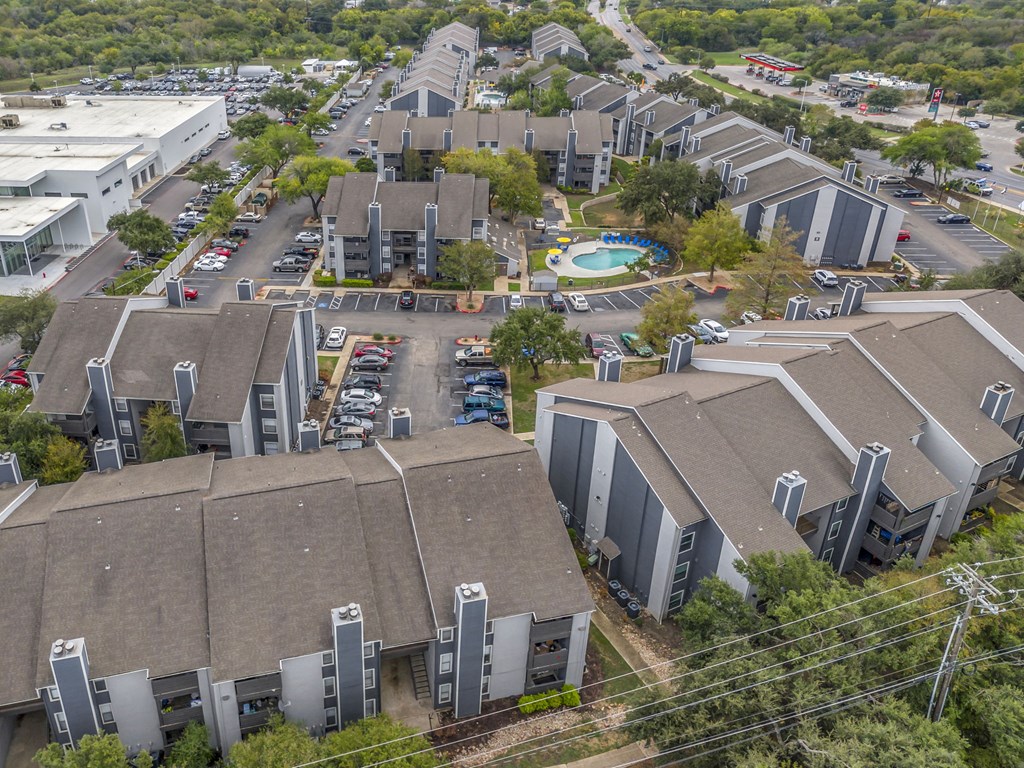 an aerial view of several buildings in a city with a parking lot