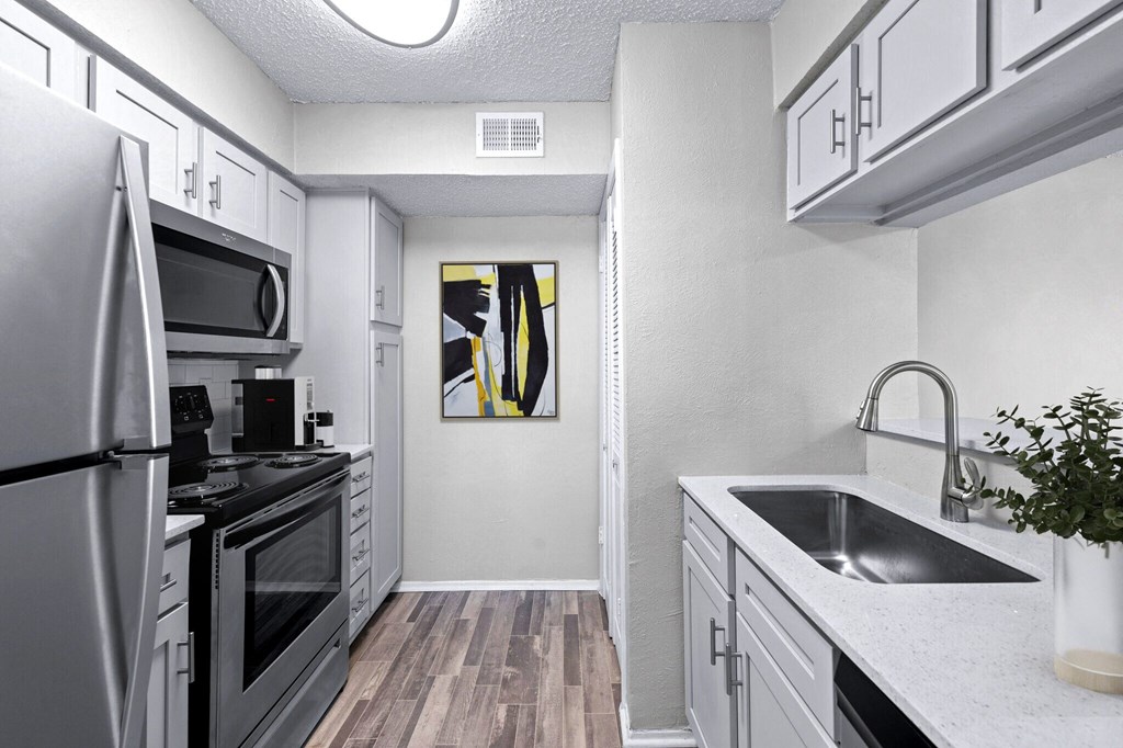 a renovated kitchen with white cabinets and stainless steel appliances