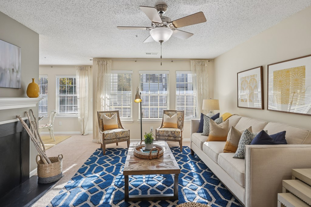 A living room with a fireplace, chairs, and a couch.
