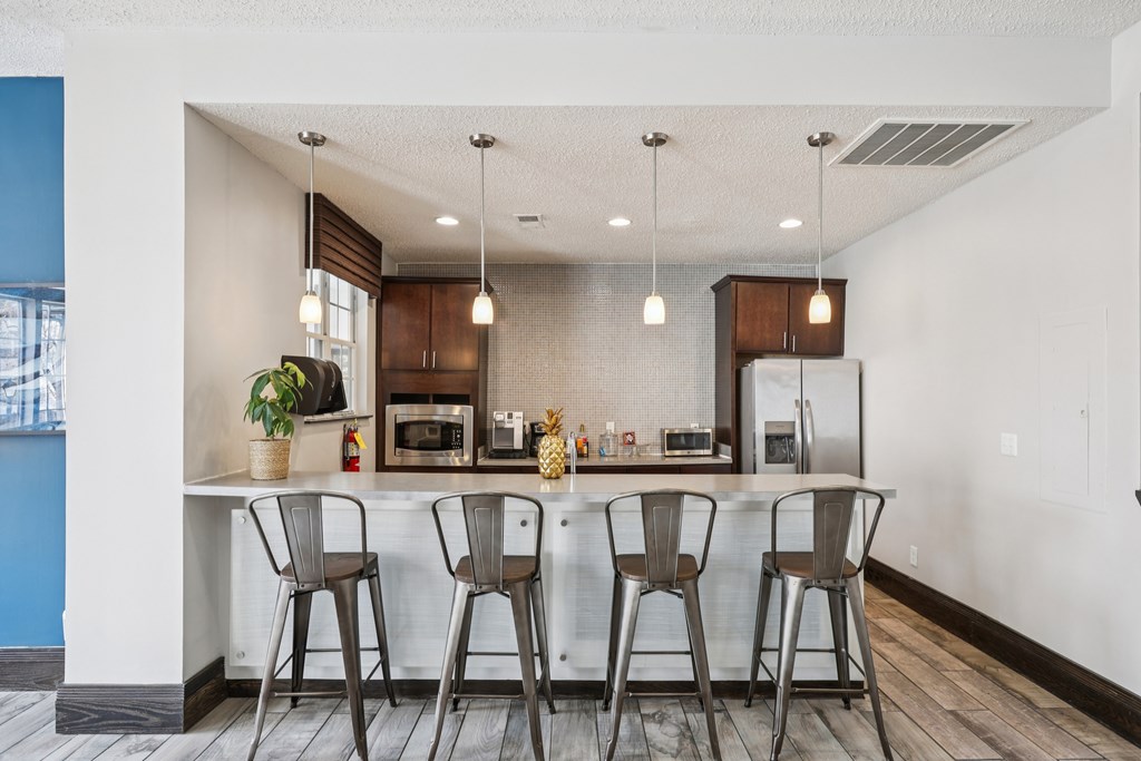 A kitchen with a bar area and four chairs.
