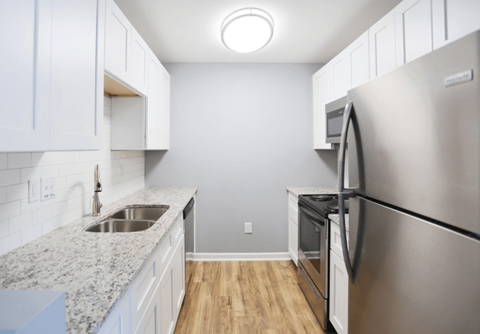 a kitchen with stainless steel appliances and white cabinets at Creekside Canopy, North Carolina  