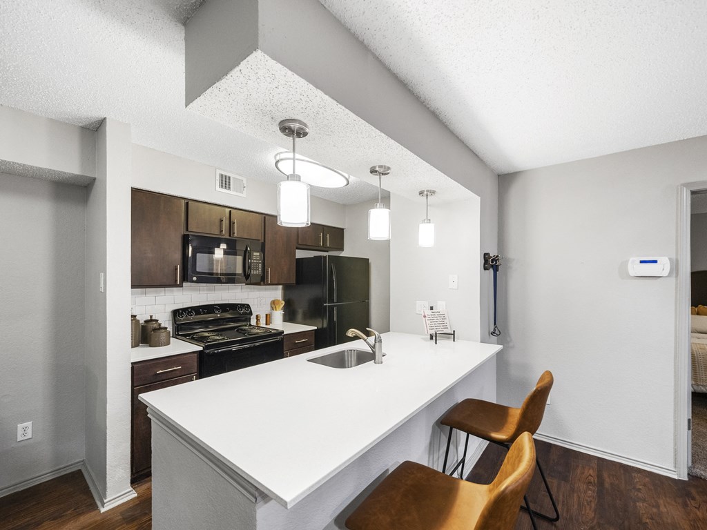Kitchen with white island  at Trinity Apartments, Texas, 75061