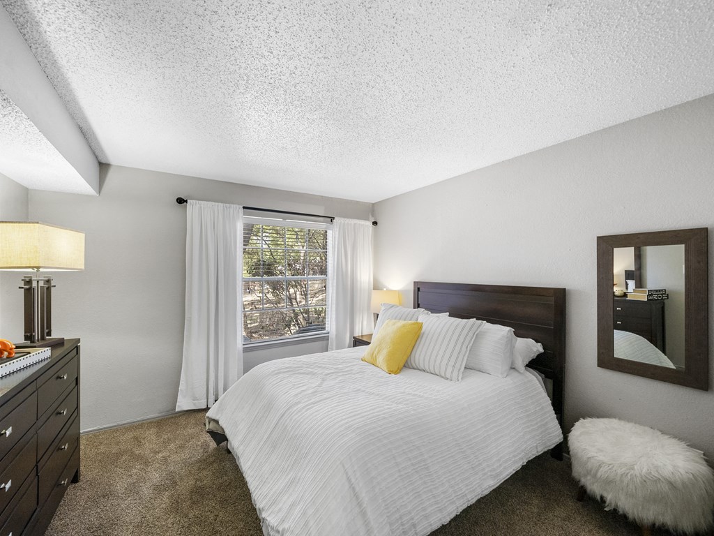 Bedroom with a bed and a window at Trinity Apartments, Irving, TX
