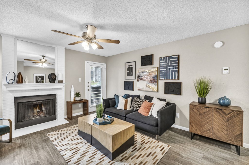 an open living room with a fireplace and a ceiling fan