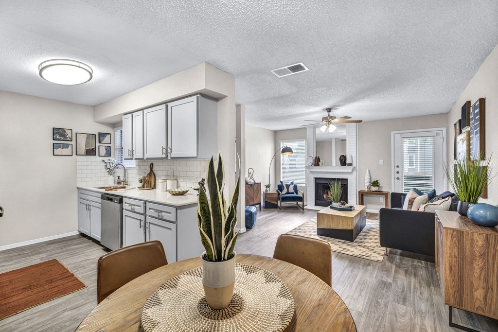 an open living room and kitchen with a table and chairs