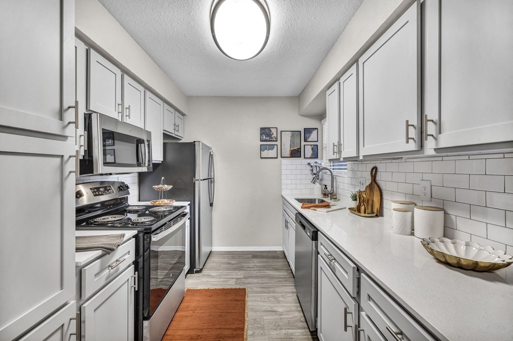 a kitchen with white cabinets and stainless steel appliances