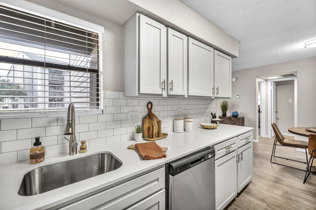 an open kitchen with white cabinets and a sink