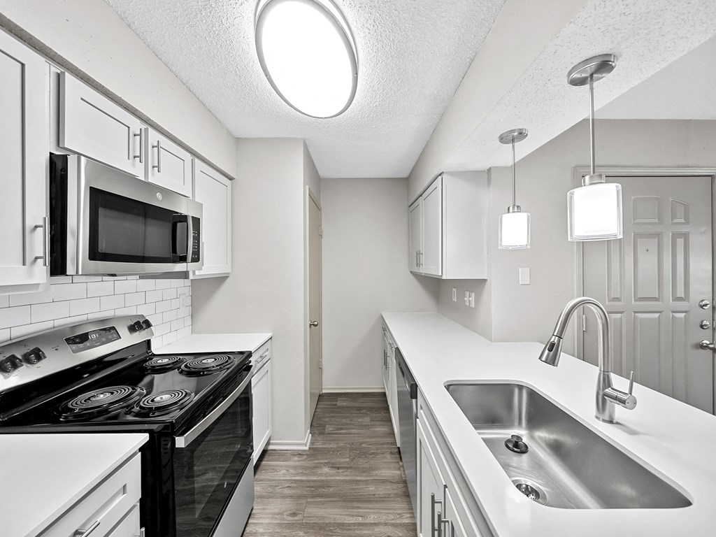Kitchen with white cabinets at Trinity Apartments, Texas, 75061