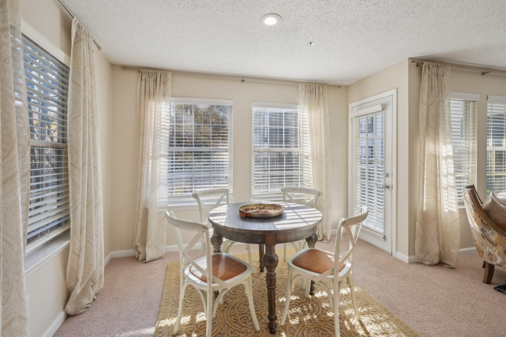 A dining room with a round table and chairs.
