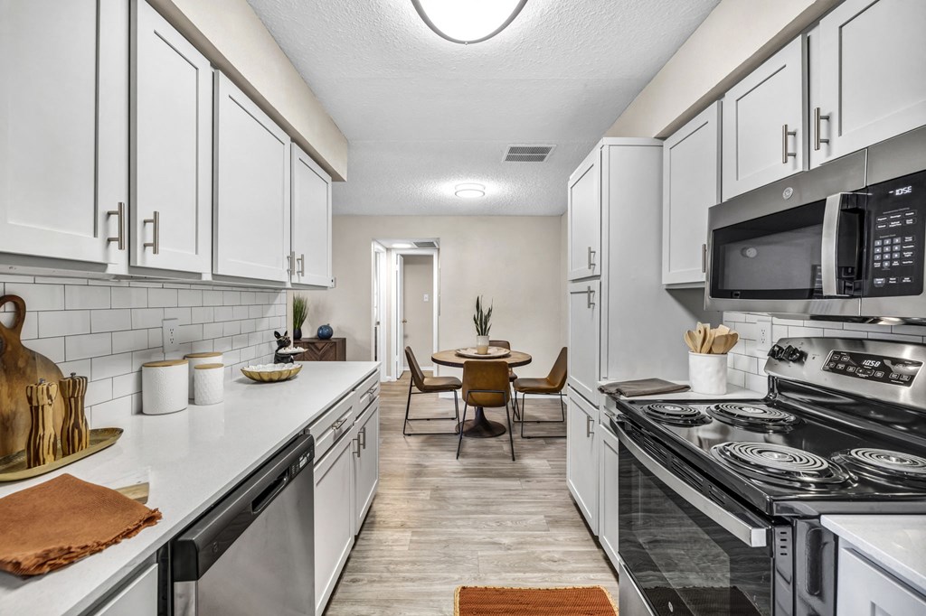 a kitchen with white cabinets and a stove and a microwave