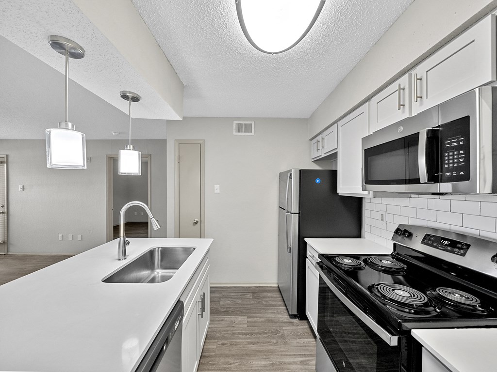 Kitchen with white countertops at Trinity Apartments, Irving, TX, 75061