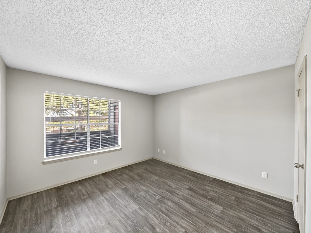 Bedroom with large windows at Trinity Apartments, Irving, 75061