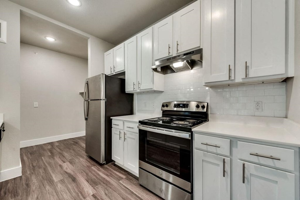 a kitchen with white cabinets and stainless steel appliances