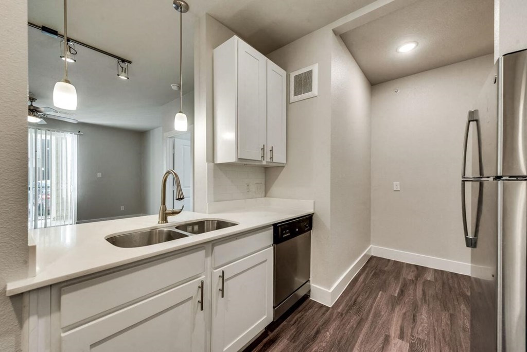 a white kitchen with a sink and a refrigerator