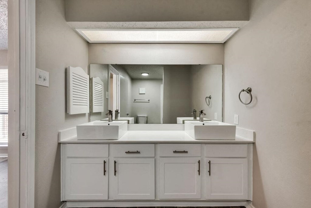 a bathroom with two sinks and a large mirror