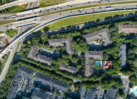 A bird's eye view of a residential area with houses and a highway.