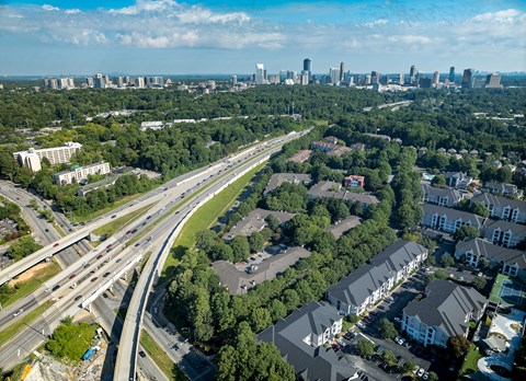 A highway interchange with a city skyline in the distance.